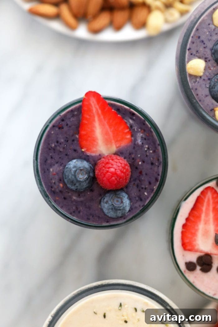 A bright purple triple berry protein shake in a tall glass, garnished with fresh berries, radiating health and freshness.