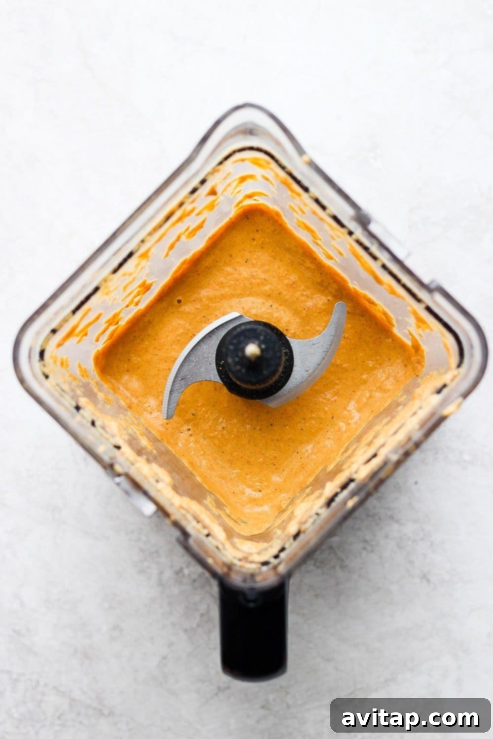 creamy vegan queso being blended in a high-speed blender
