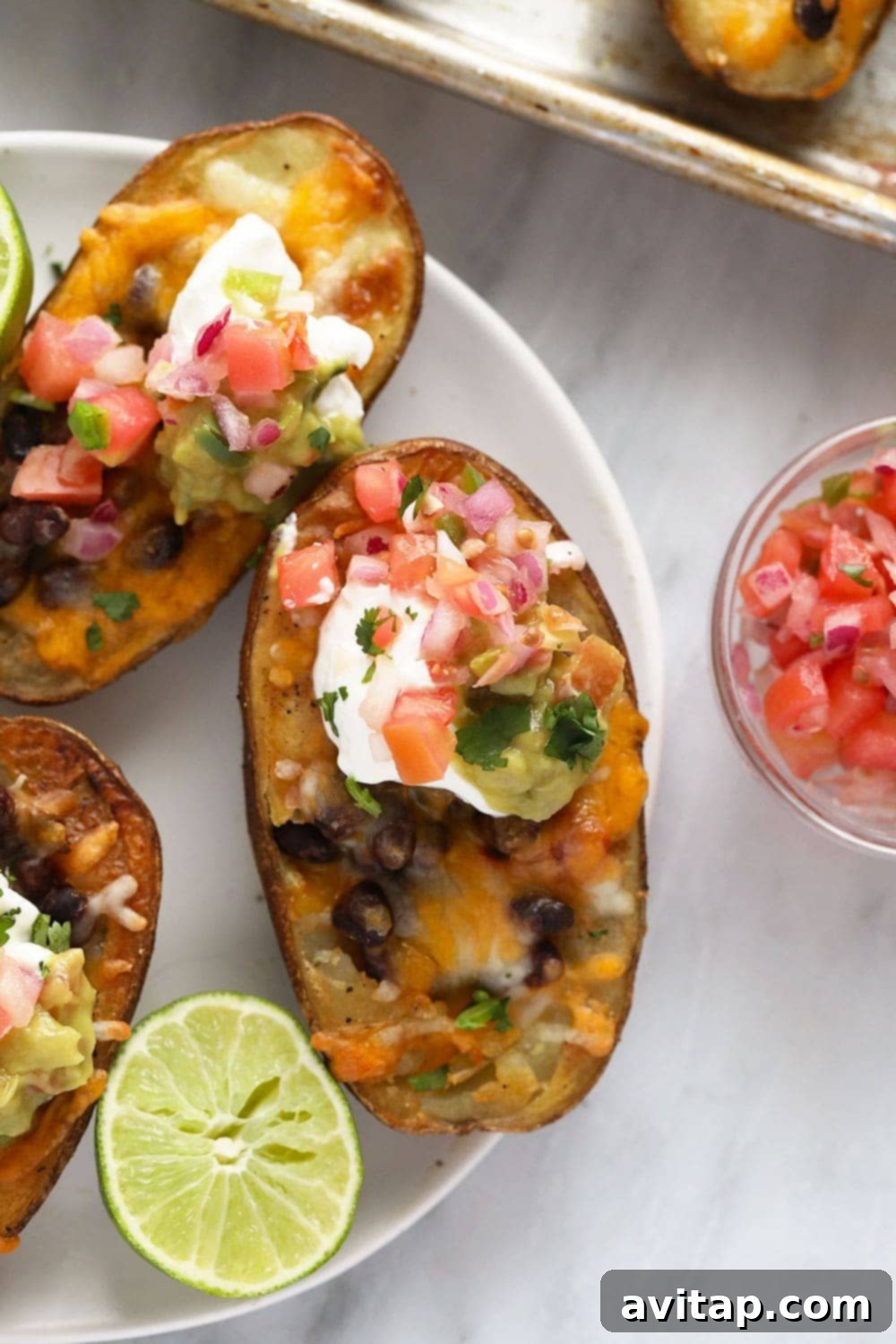 Vegetarian Mexican potato skins arranged beautifully on a serving plate, garnished with fresh cilantro and a side of guacamole.