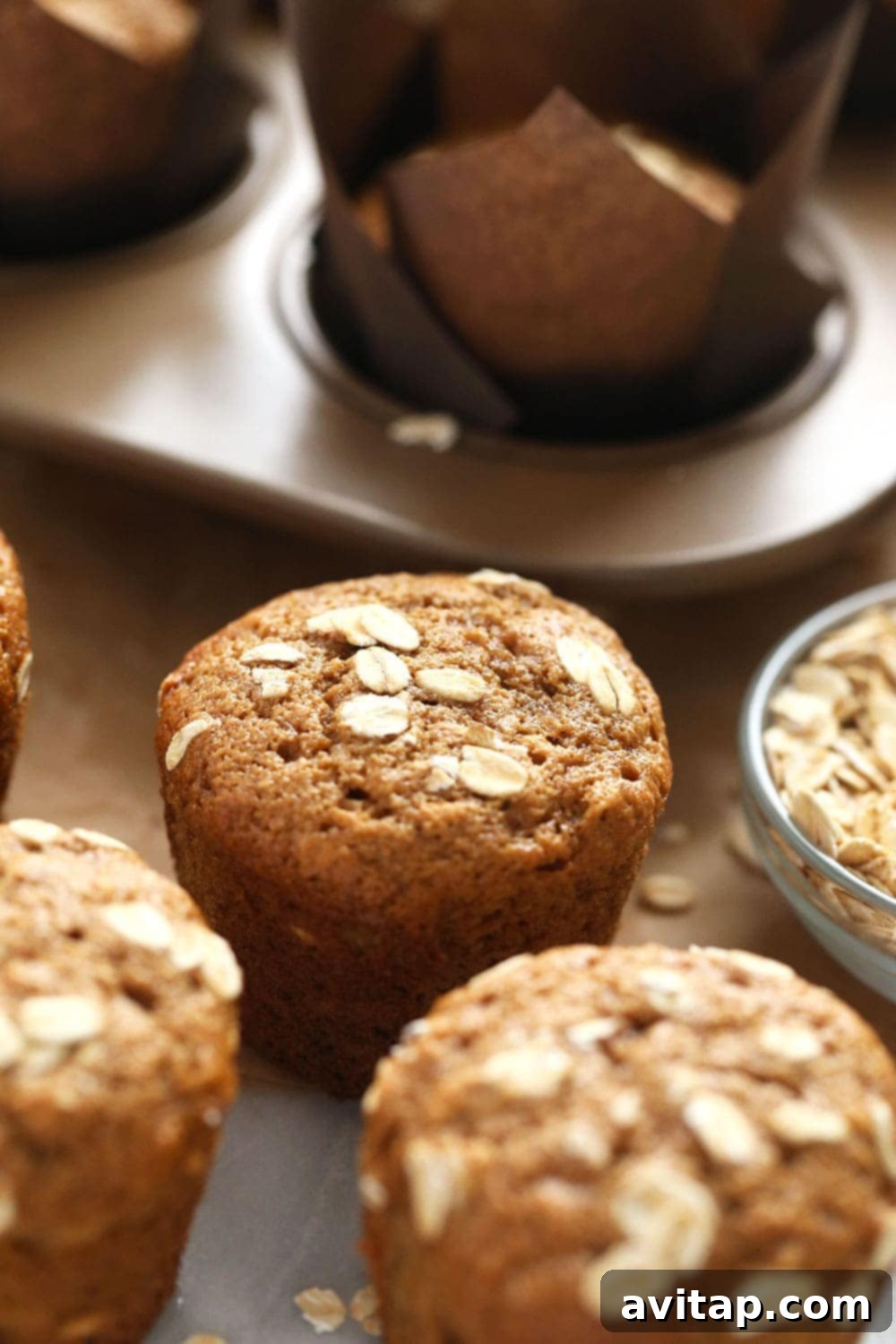 Hearty Oatmeal Muffins 2 Delicious Classic Oatmeal Muffins topped with rolled oats, ready to be enjoyed as a healthy snack or breakfast.