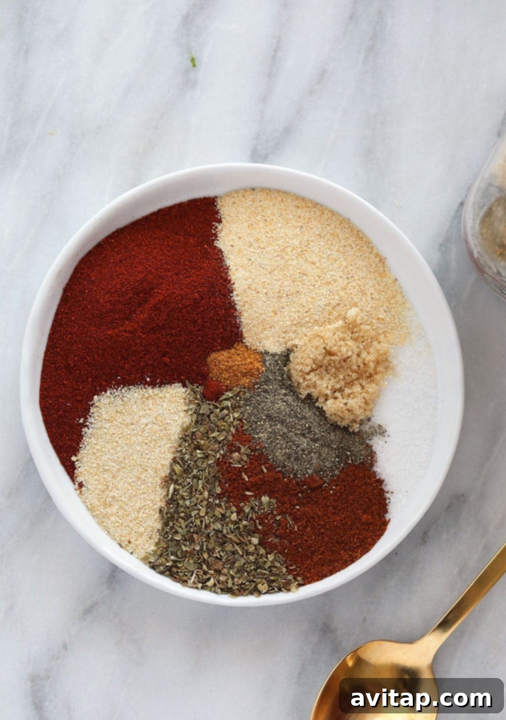 Homemade Cajun Seasoning displayed on a small white plate, showcasing its rich color and texture.
