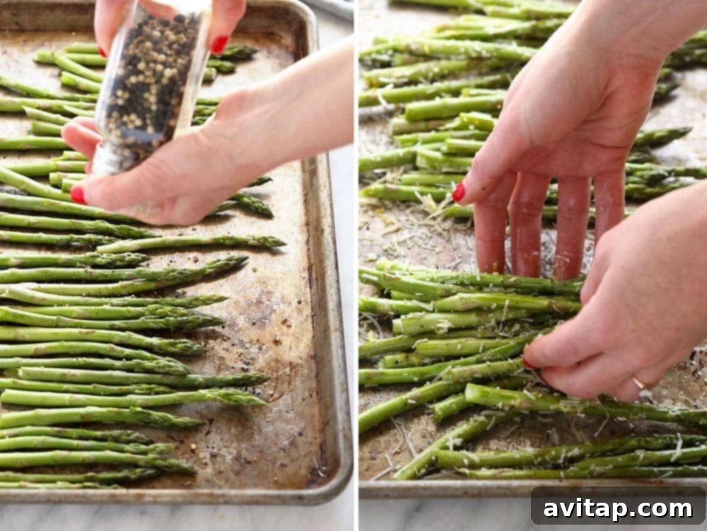 Seasoning asparagus with salt and pepper on a baking sheet before roasting.