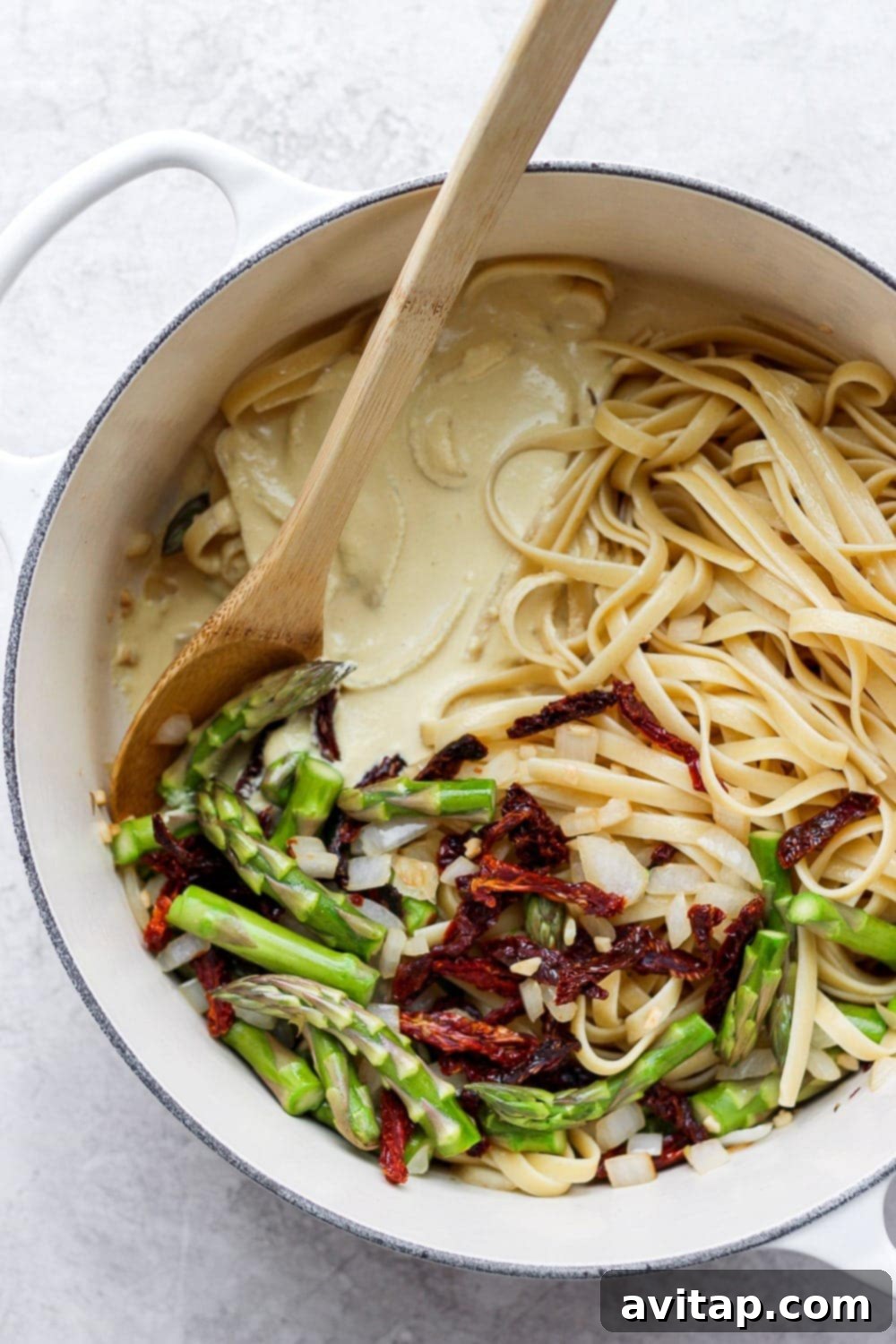 Velvety Vegan Asparagus Pasta 5 creamy vegan asparagus pasta in a dutch oven ready to be tossed together with veggies and creamy sauce