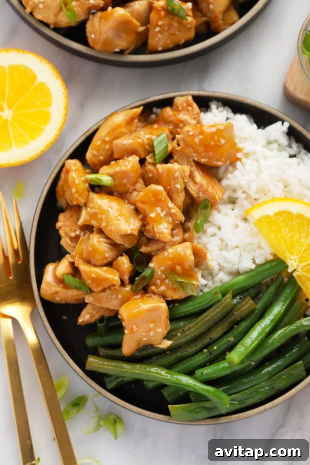 This Instant Pot Orange Chicken is saucy, flavorful, and so easy to make! All you need is your Instant Pot and the ingredients and you will have delicious take-out-tasting orange chicken in less than 30 minutes! Orange chicken, white rice, and green beans on a plate