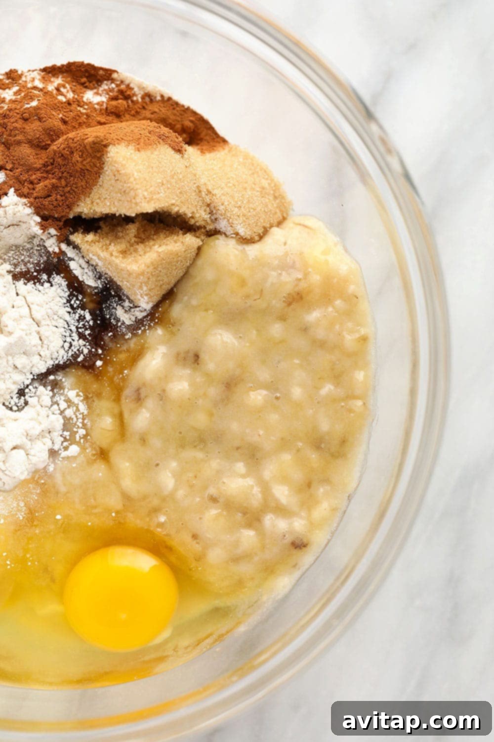 Mashed Banana and Muffin Ingredients Bowl with mashed bananas, eggs, maple syrup, and almond milk, ready to be mixed for muffin batter.