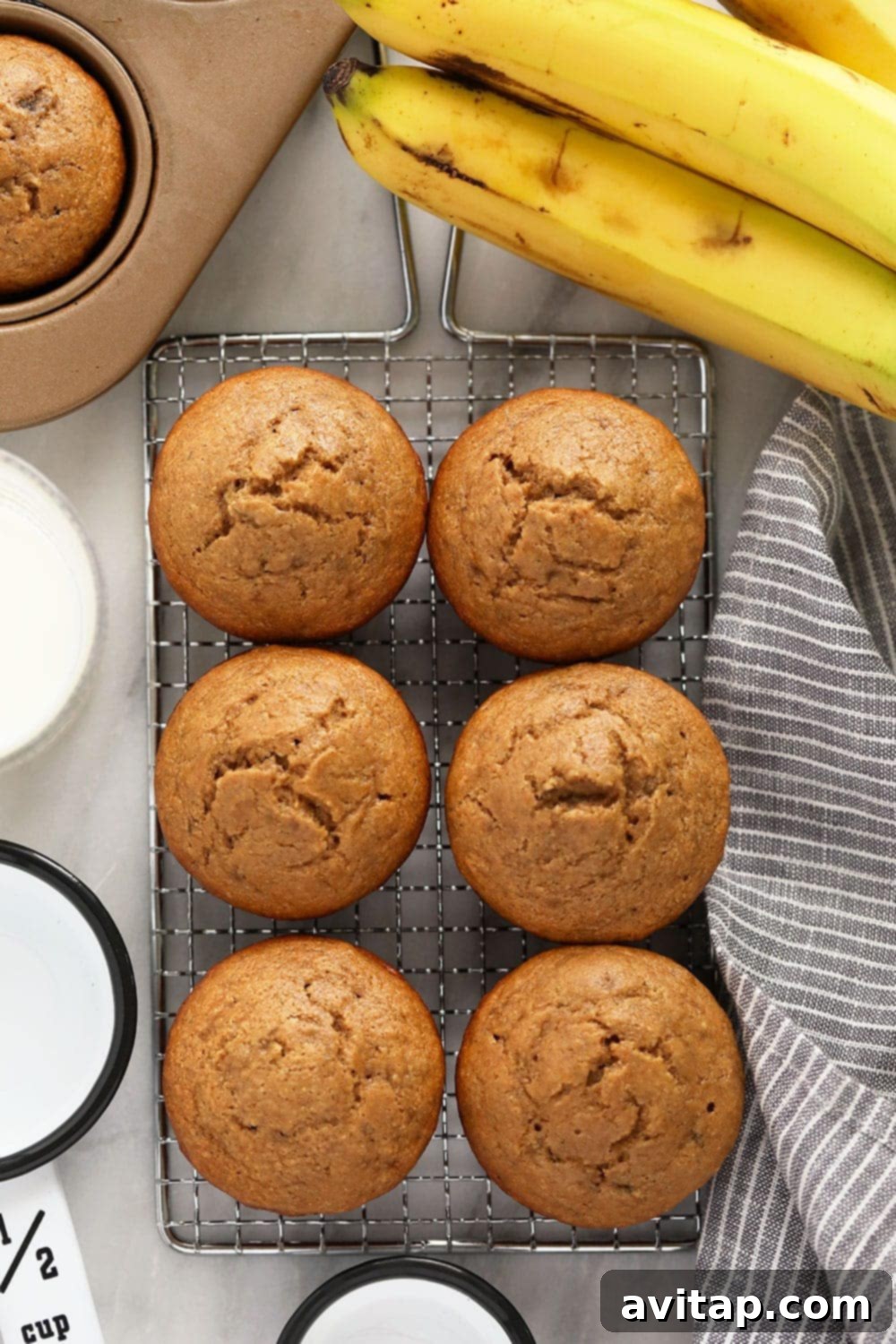 Baked Banana Muffins Close-up of baked healthy banana muffins cooling on a rack, showcasing their golden-brown tops.