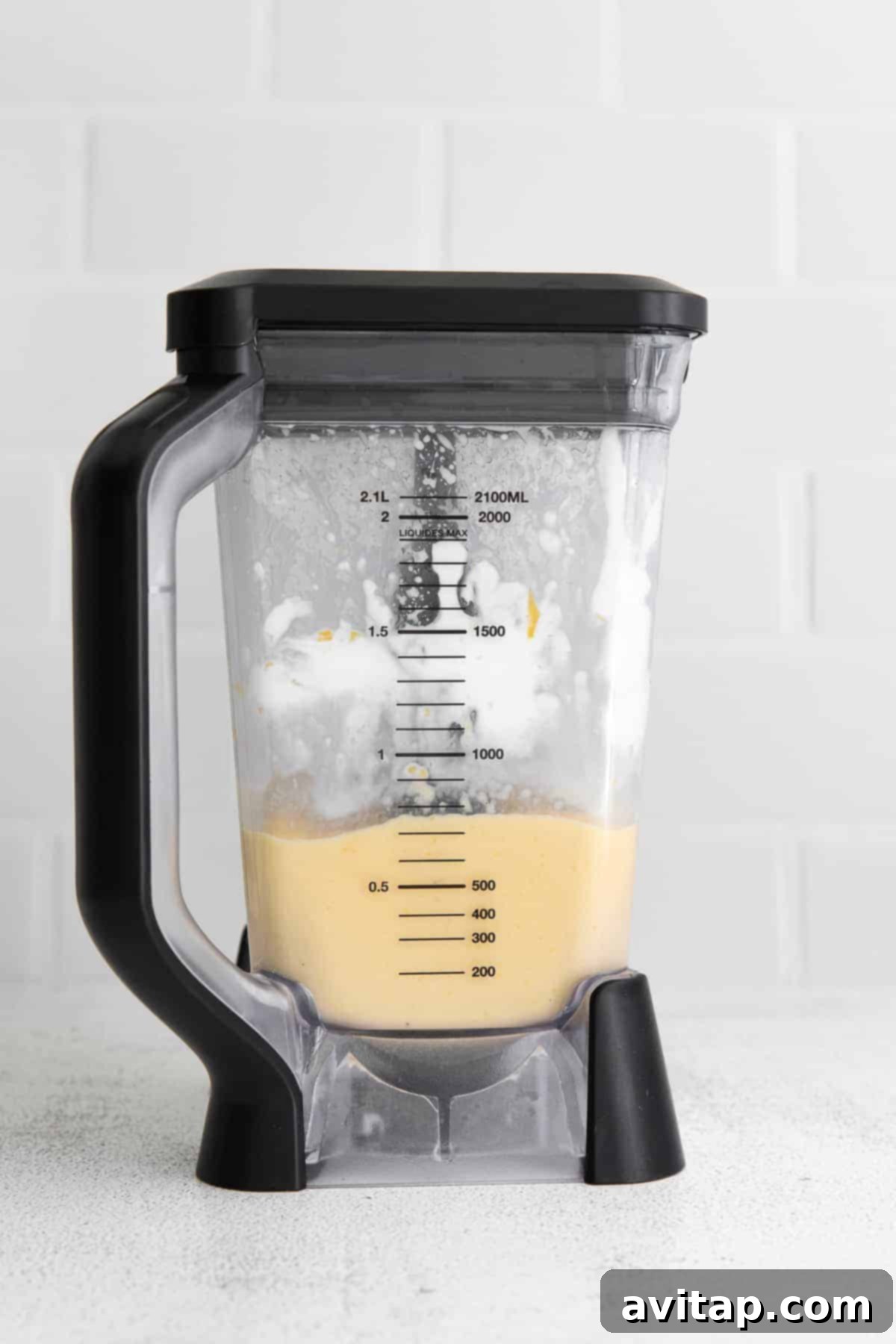 A high-speed blender mixing a creamy mango smoothie to a perfect, thick consistency.