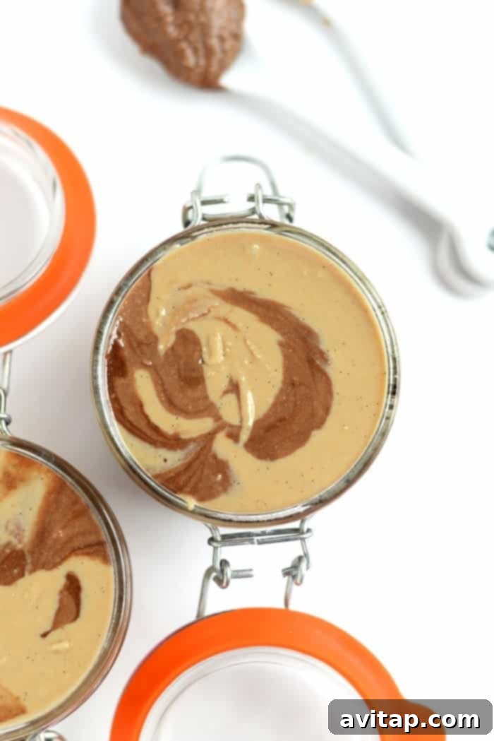 Close-up of a jar filled with Chocolate Vanilla Swirl Cashew Butter, showcasing the delicious marbled effect.