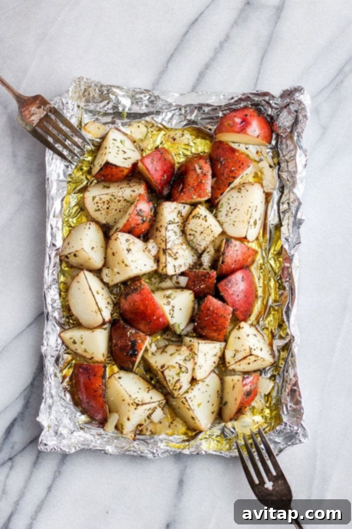 Grilled red potatoes cooking in a foil pack on a BBQ