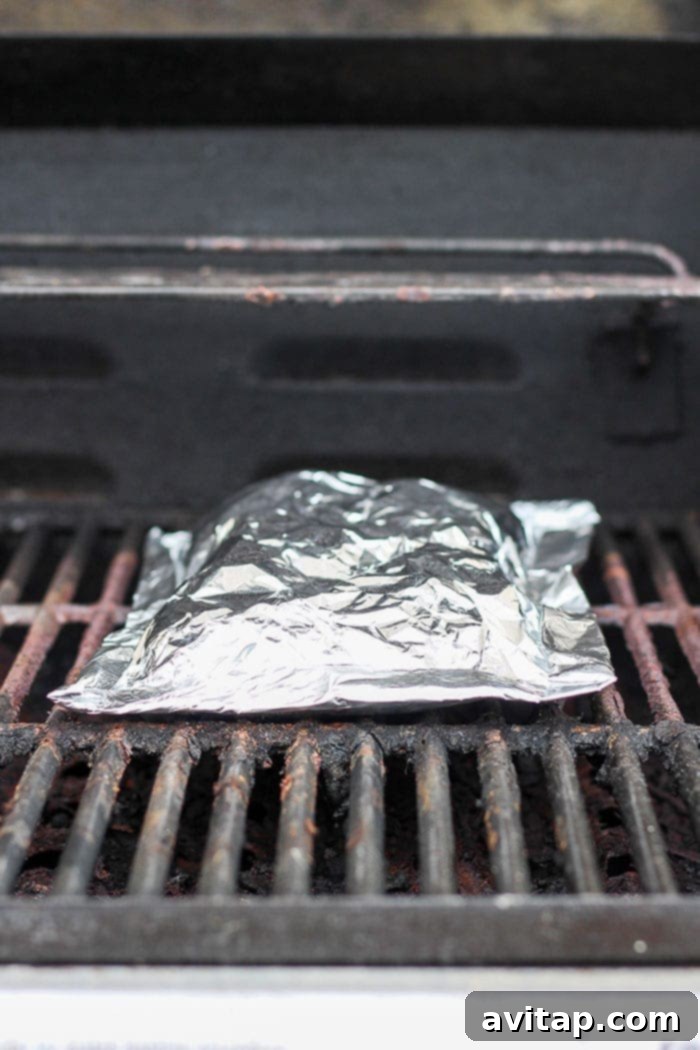 Foil pack of potatoes cooking on a hot grill