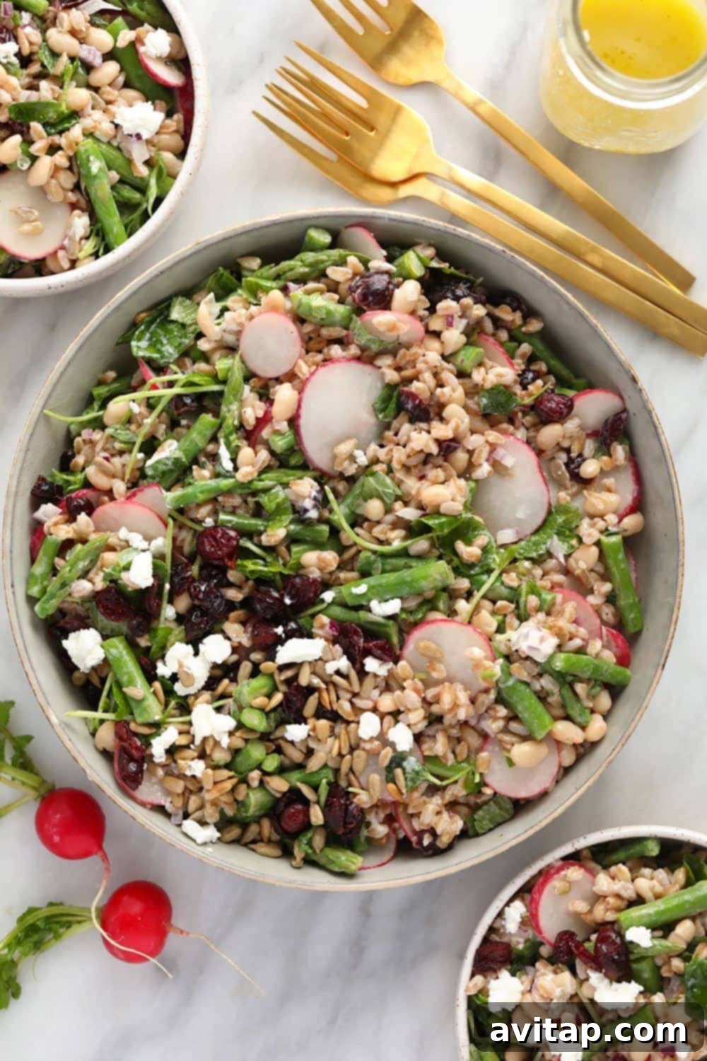 A beautifully presented farro salad in a large serving bowl, garnished with fresh herbs.