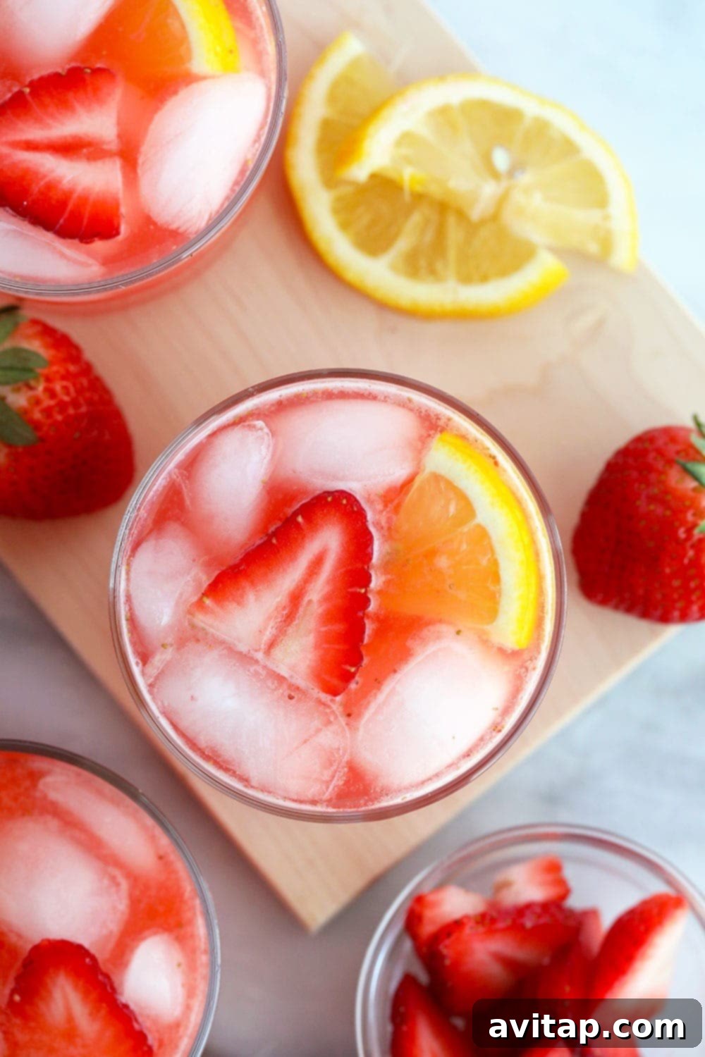 This Strawberry Vodka Lemonade is made with fresh strawberry puree, fresh squeezed lemons and a honey simple syrup, plus vodka, of course! Get ready for your new favorite homemade cocktail. A refreshing glass of strawberry vodka lemonade, garnished with fresh strawberries and a lemon wedge.