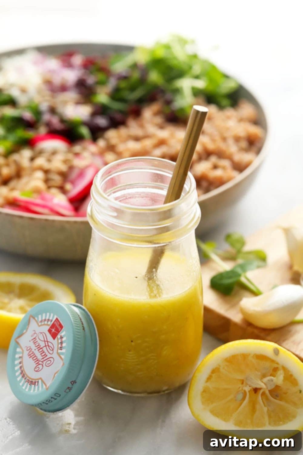 Bright and fresh homemade lemon vinaigrette dressing in a clear glass jar, ready to be poured over a salad.