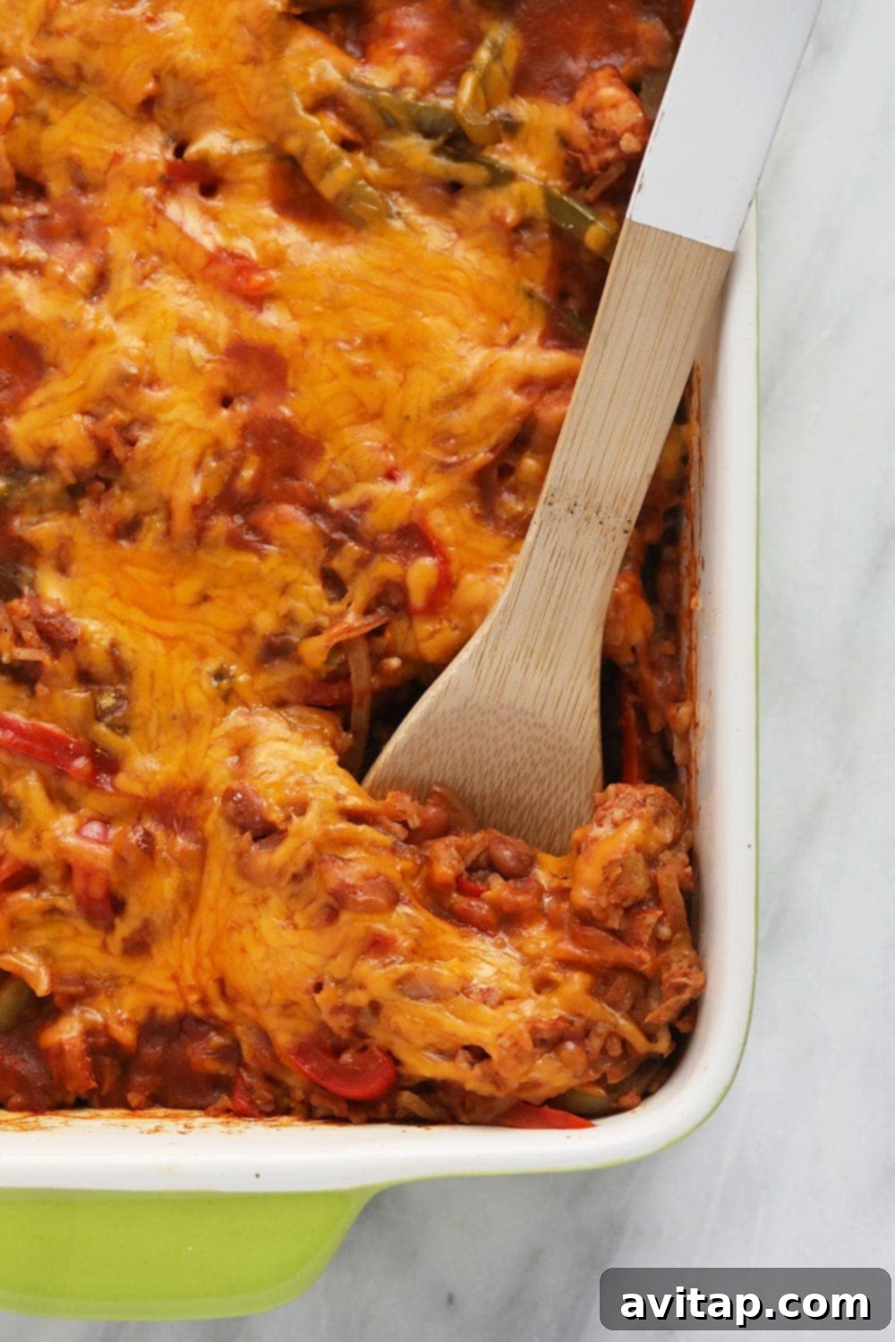 Scooping Chicken Burrito Bowl Casserole from a dish with a serving spoon