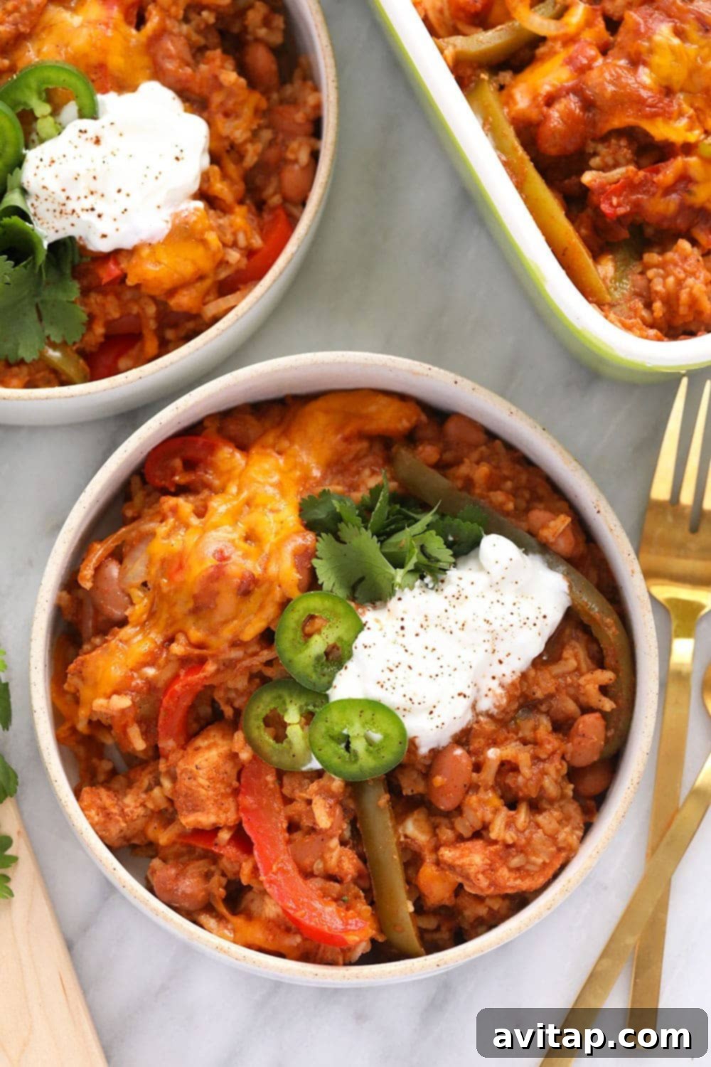 Healthy Chicken Burrito Bowl Casserole in a bowl, garnished with jalapeños and Greek yogurt