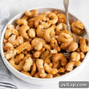 A square image of beautifully roasted cashews with sesame seeds.