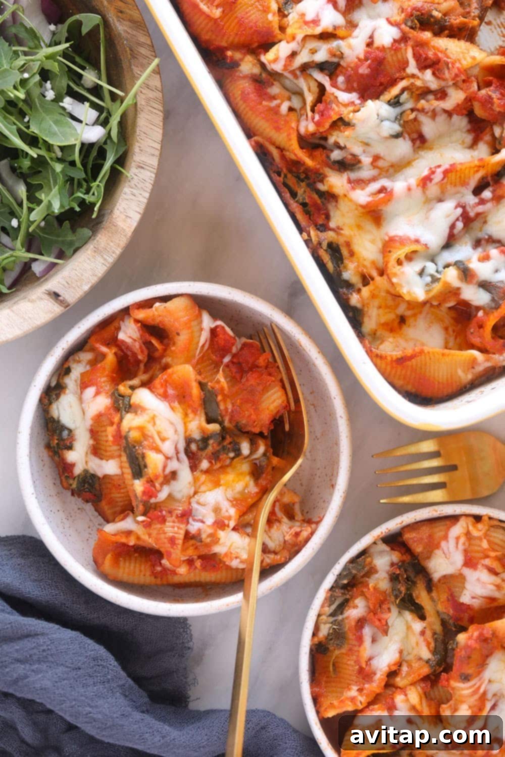 A single serving of vegetarian sweet potato, spinach, and ricotta stuffed shells, beautifully plated in a bowl, garnished with fresh herbs.