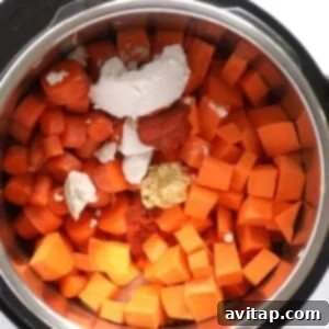 An Instant Pot filled with carrot soup and other ingredients, before cooking.