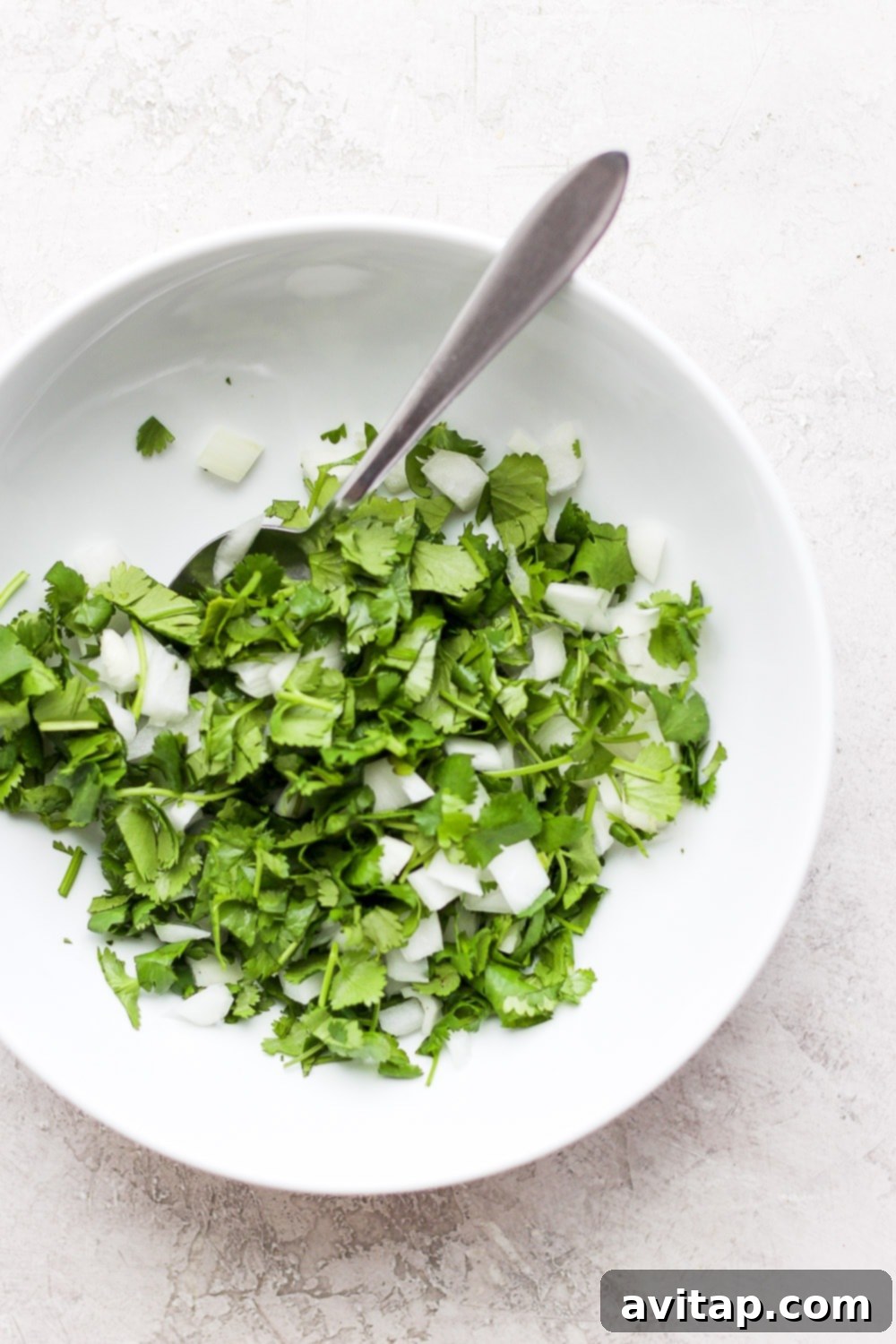 Freshly chopped cilantro and diced white onion, a key topping for shredded chicken tacos