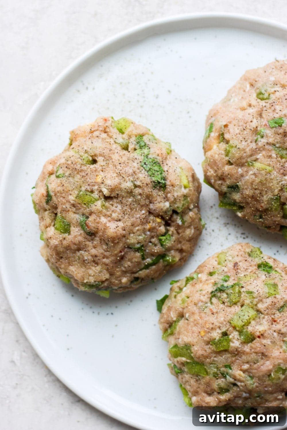 Say hello to the Best Juicy Turkey Burger you've ever had! These turkey burgers are always delicious, and never dry. Enjoy! Perfectly formed raw turkey burger patties arranged on a plate.