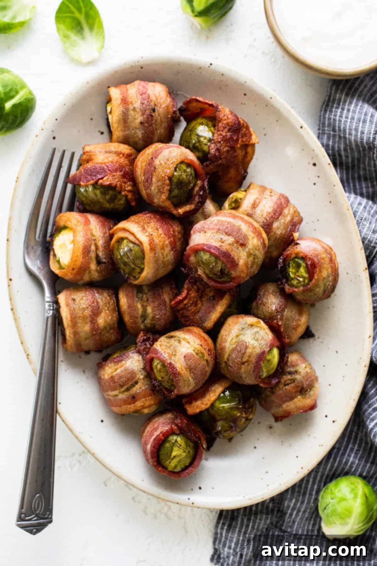 A close-up of crispy bacon-wrapped Brussels sprouts on a plate, ready to be served.