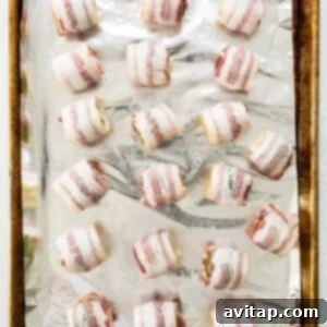 Raw bacon-wrapped Brussels sprouts neatly arranged on a baking sheet.