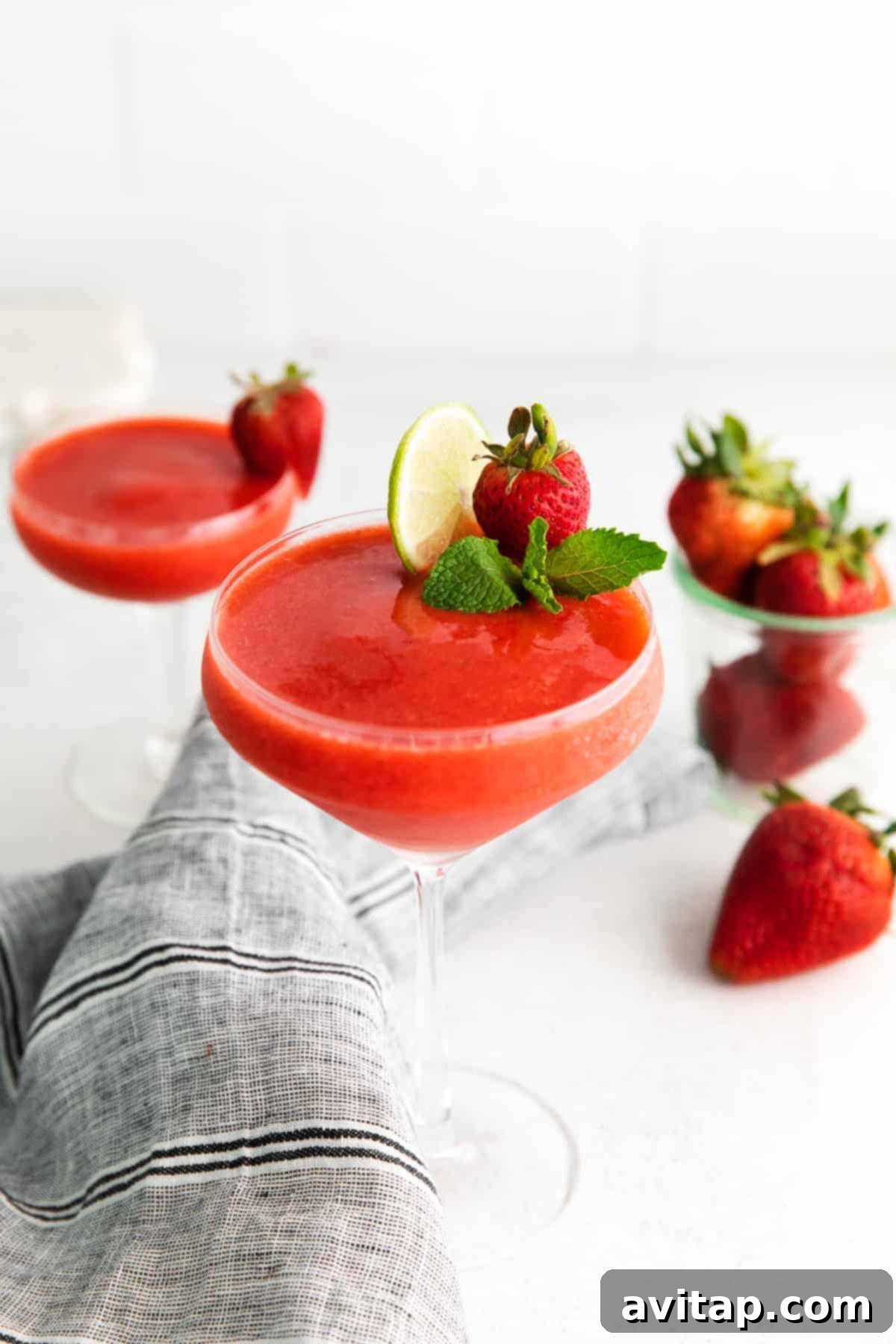 Blend up your own strawberry daiquiri recipe at home for the most delicious frozen drink ever! And bonus: this drink recipe has NO refined sugar! strawberry daiquiri with lime and fresh mint