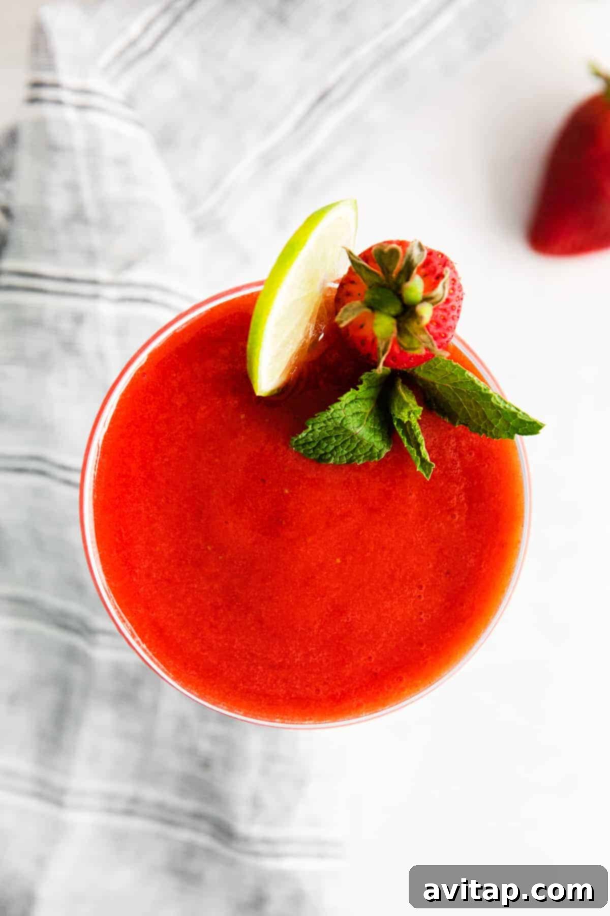 A seriously delicious frozen strawberry daiquiri made with just 4 ingredients - frozen strawberries, lime juice, simple syrup, and rum. daiquiri in glass