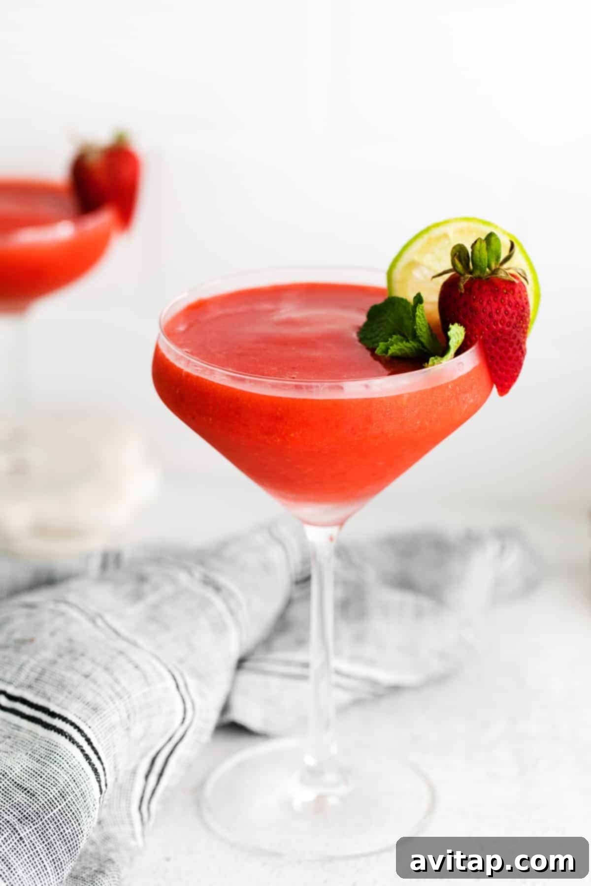 Blend up your own strawberry daiquiri recipe at home for the most delicious frozen cocktail ever. This strawberry daiquiri is made with frozen strawberries, rum, and a simple syrup. strawberry daiquiri in glass