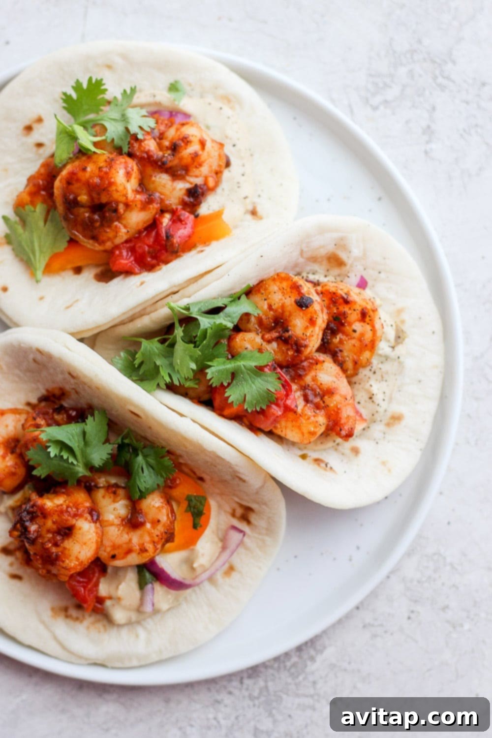 Delicious shrimp tacos topped with fresh cilantro, ready to be enjoyed on a plate