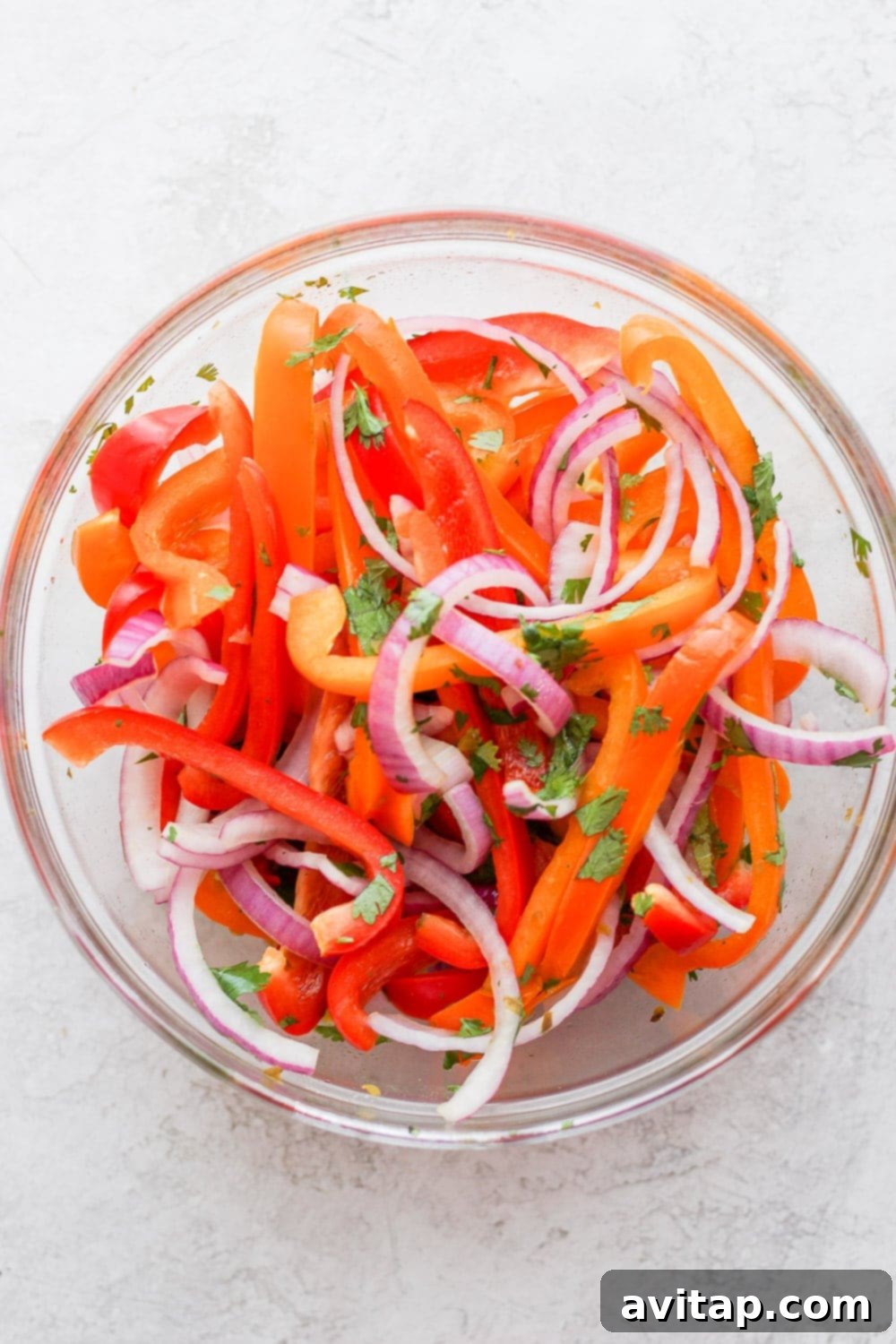 Vibrant sweet pepper slaw being thoroughly mixed together in a large bowl