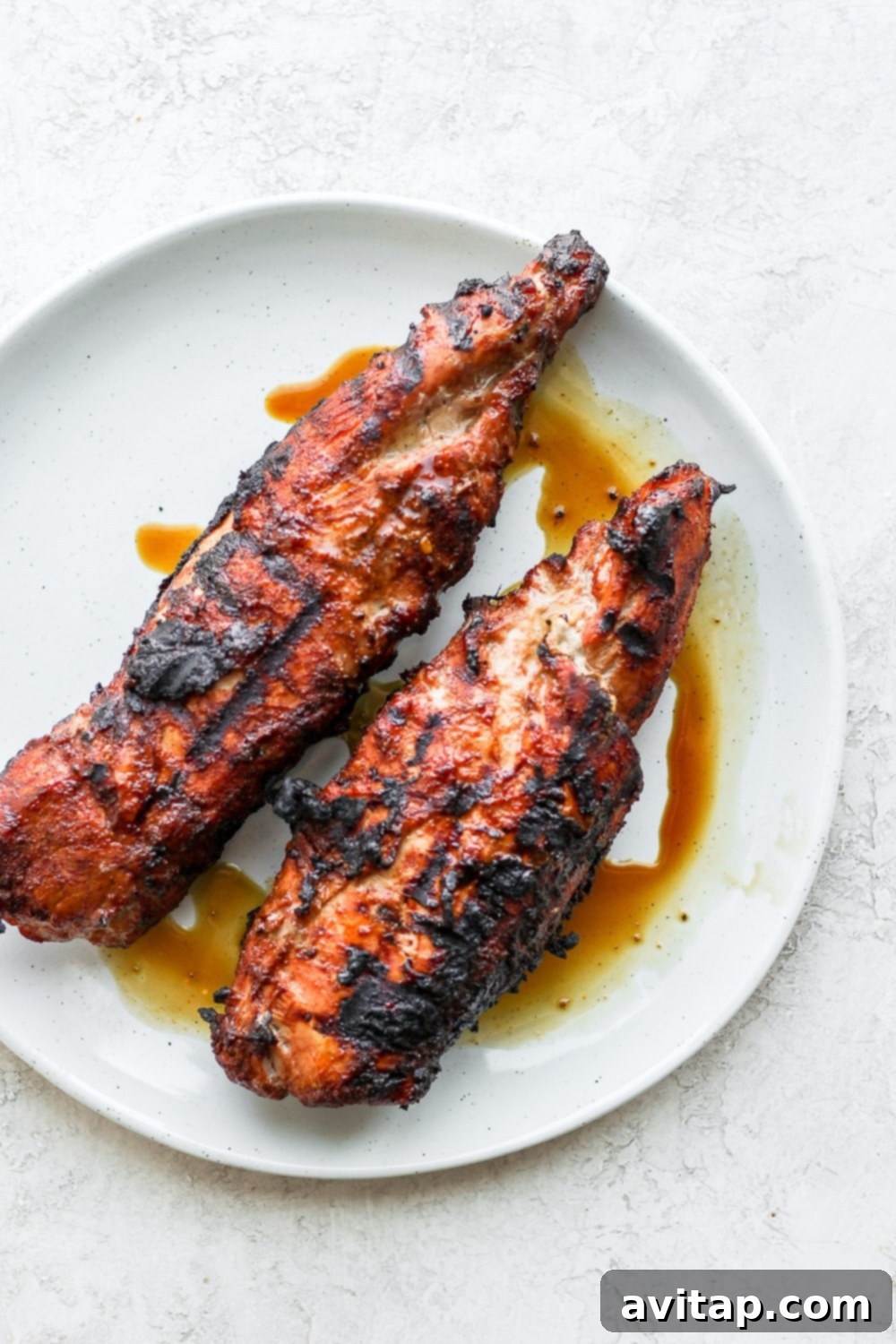 A serving of sliced grilled pork tenderloin on a plate, ready to be enjoyed.
