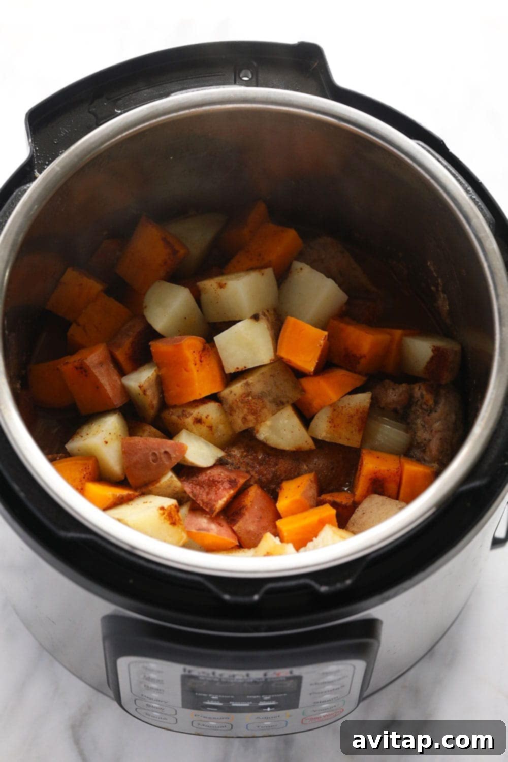 Pork tenderloin and potatoes cooking together in the Instant Pot.