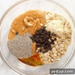 A bowl filled with all the dry and wet ingredients for peanut butter protein balls.