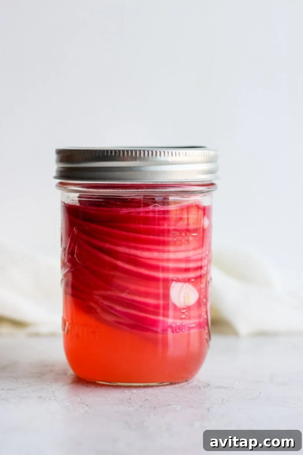 Homemade Quick Pickled Red Onions in a Glass Jar Jar of vibrant quick pickled red onions ready to eat