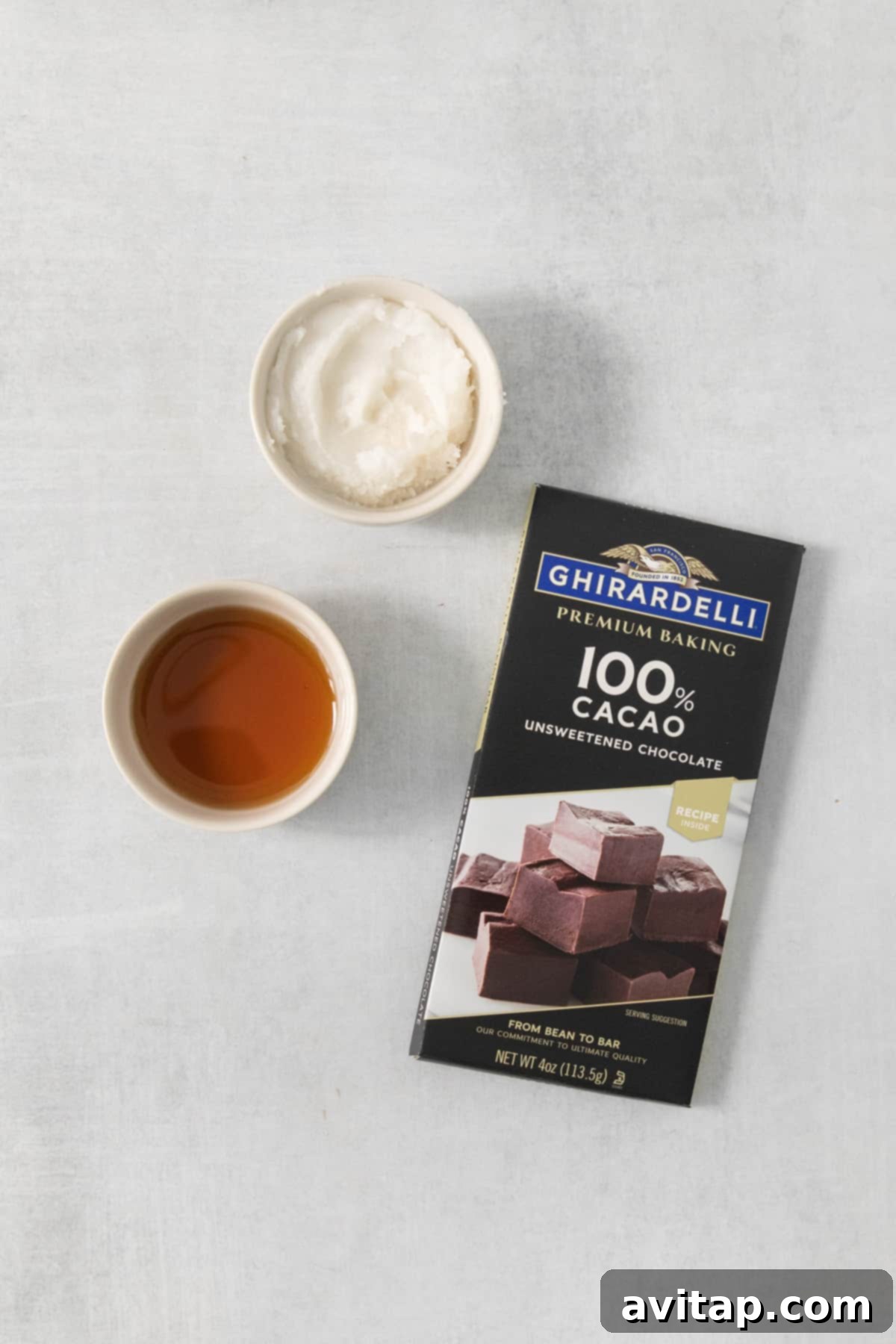 A high-quality bar of 100% unsweetened baking chocolate rests beside a steaming cup of tea, highlighting the simplicity of the main ingredient.