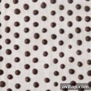 A black and white image capturing the process of piping small, round chocolate dots onto a white background, forming perfect vegan chocolate chips.