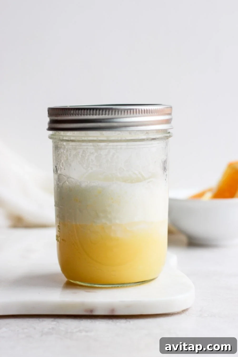 Velvet Orange Dream 4 A vibrant orange creamsicle cocktail being shaken vigorously in a mason jar, demonstrating how to create a rich froth without specialized bar equipment.