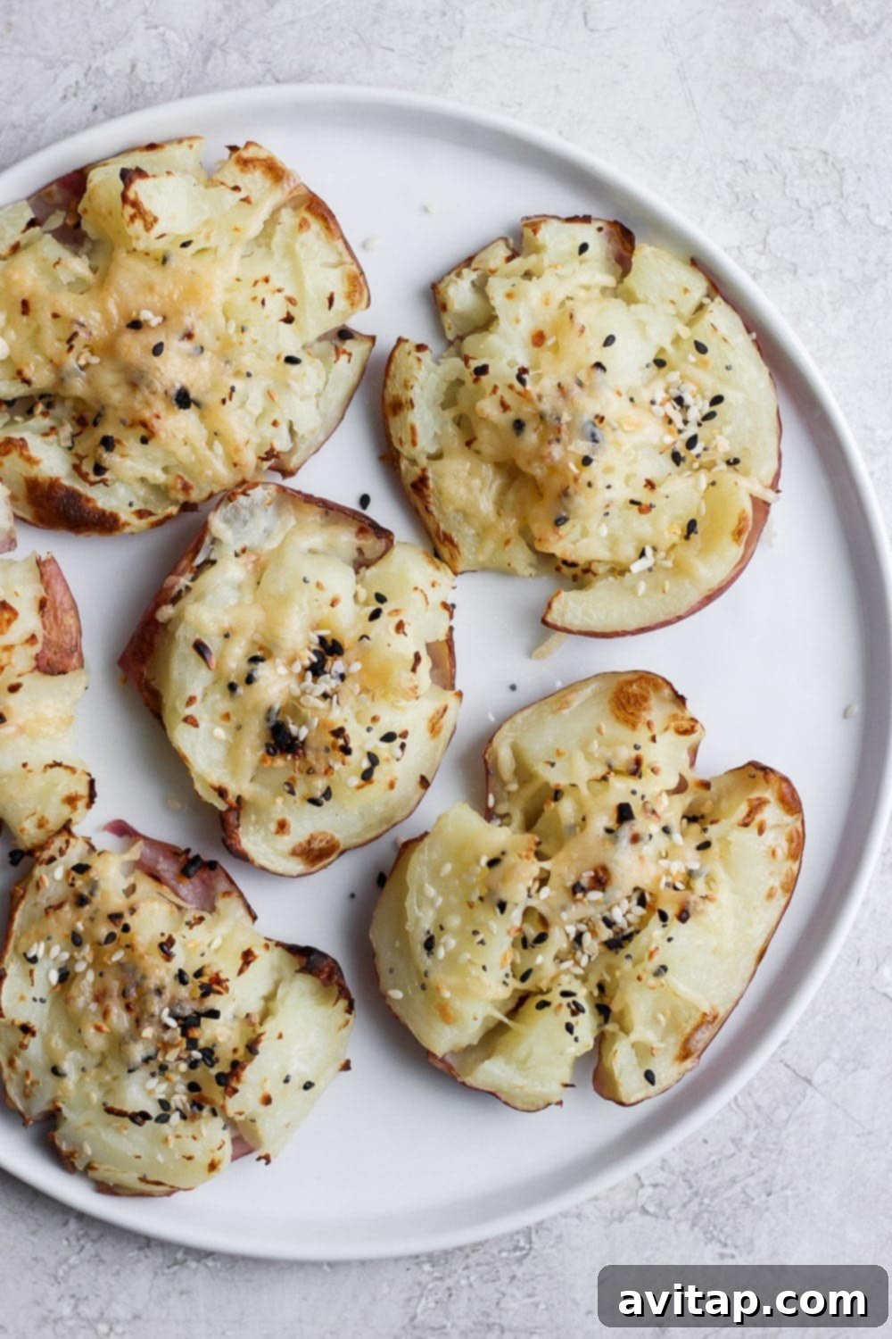 Crispy Smashed Red Potatoes - A delicious and easy side dish for any meal. Perfectly crispy smashed red potatoes seasoned with herbs and Parmesan cheese, served on a plate.