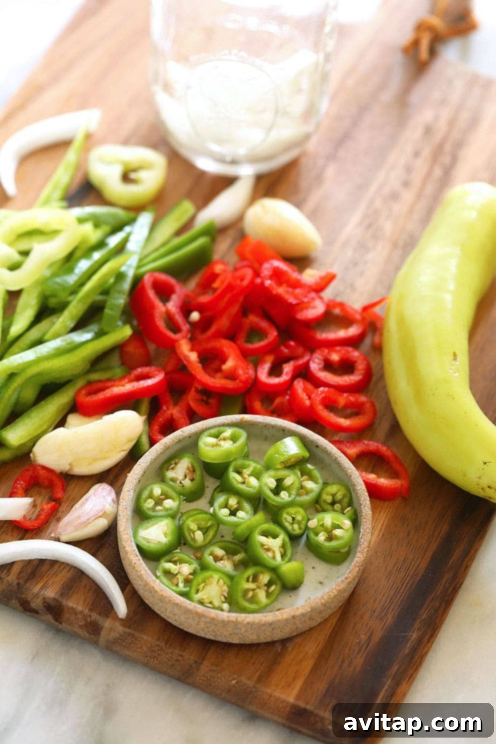 Assortment of vibrant, sliced peppers and diced onions prepared for pickling.