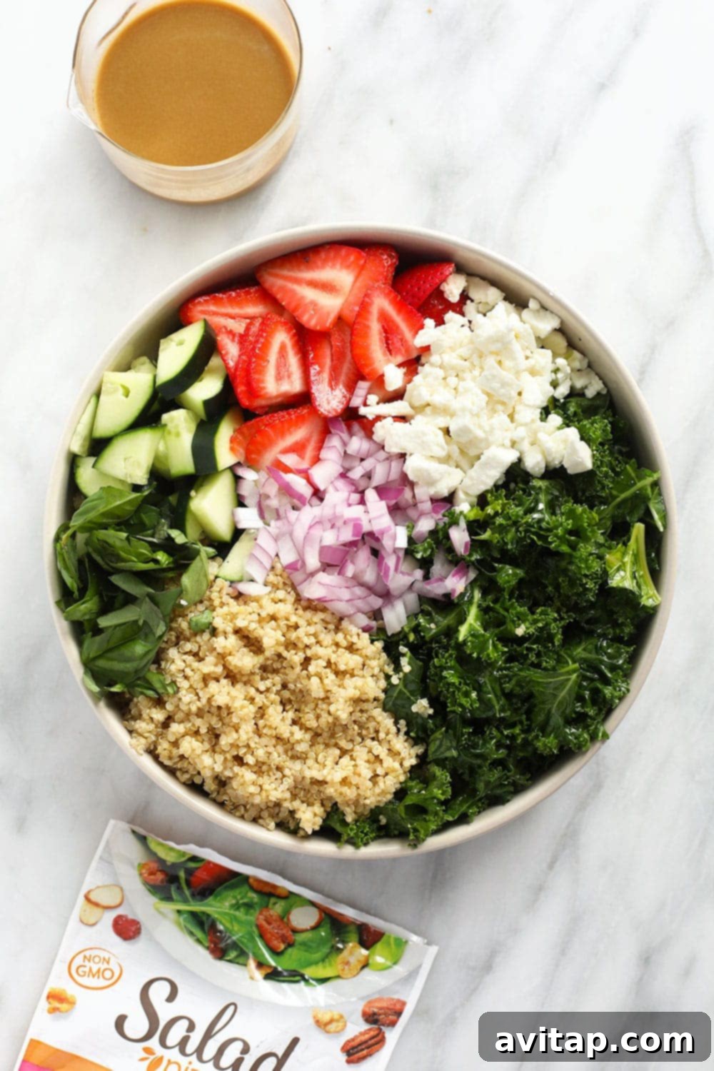 Vibrant Strawberry Quinoa Salad 3 Close-up shot of massaged kale and sliced strawberries, key components of the quinoa salad.