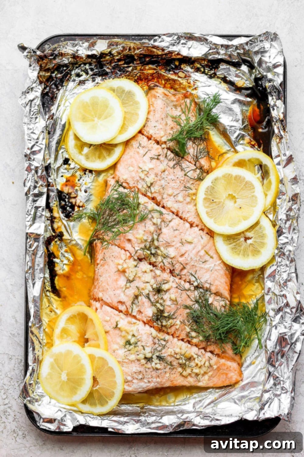 Large salmon fillet portioned into individual servings on a cutting board, illustrating the versatility of the recipe for different needs.