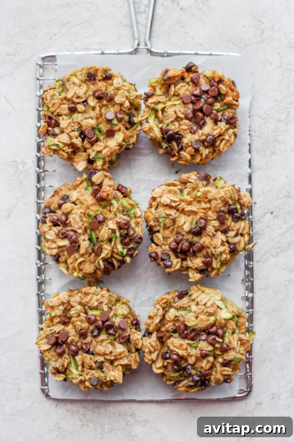 Freshly baked chocolate chip zucchini oatmeal cups cooling on a wire rack.
