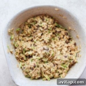 Wet ingredients being added to the dry oat mixture in a bowl.