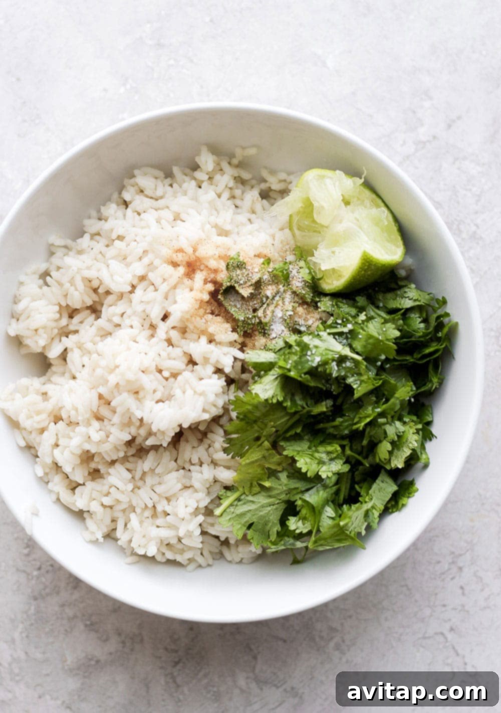 Make this cilantro lime rice for an easy and flavorful addition to any of your favorite meals! A bowl of freshly made cilantro lime rice, garnished with extra cilantro and lime wedges, ready to be served.