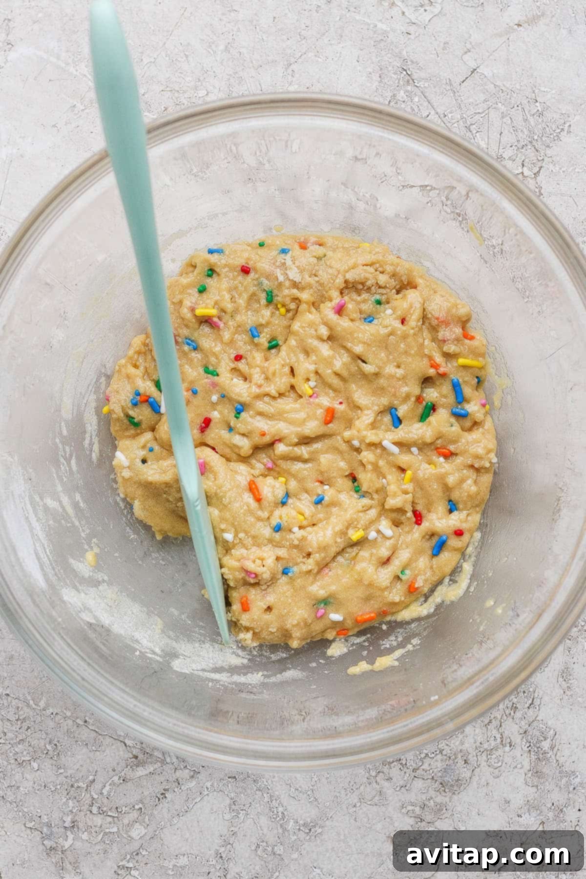 Bowl of cookie dough with colorful sprinkles.