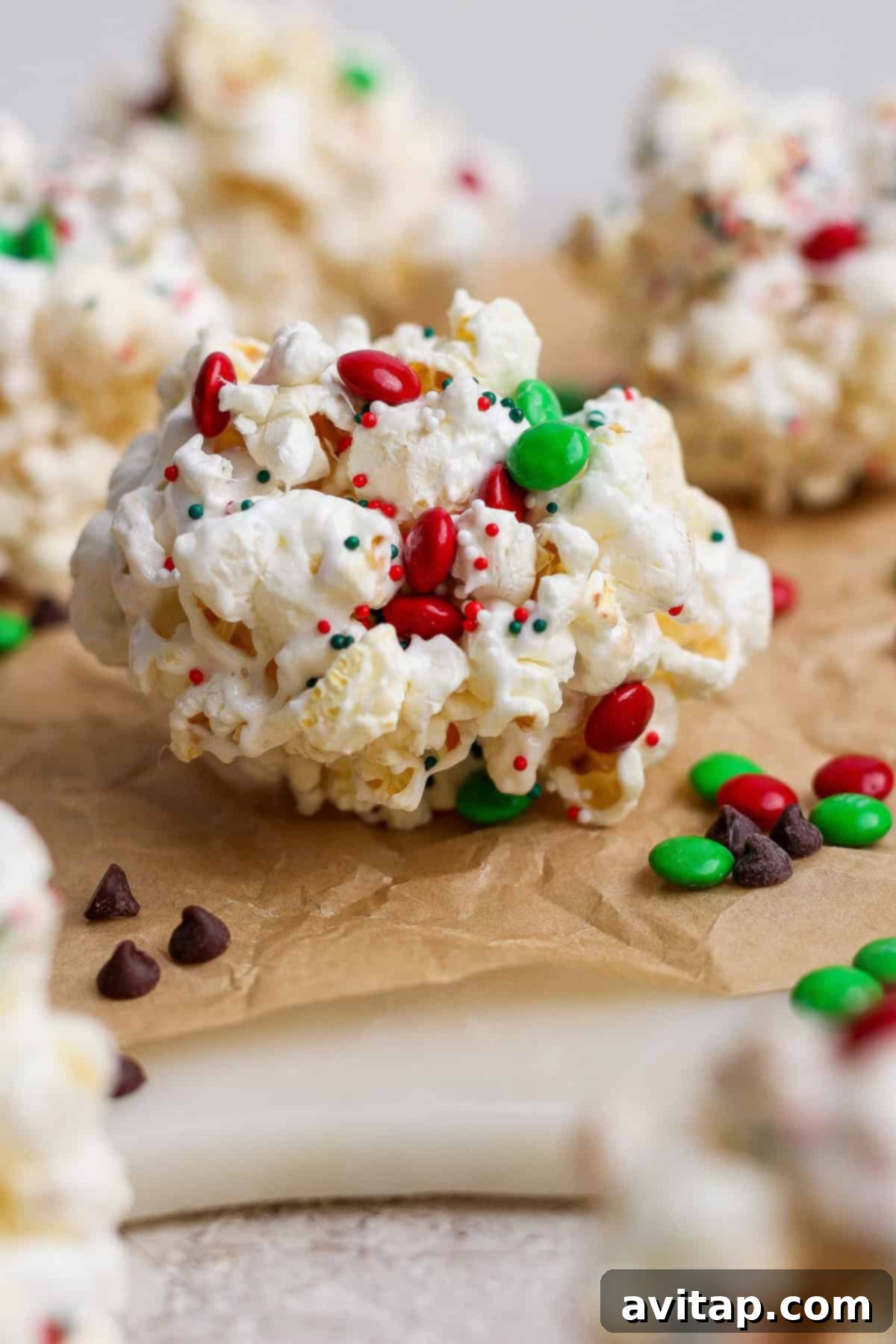 Close-up of a Christmas popcorn ball on parchment paper.