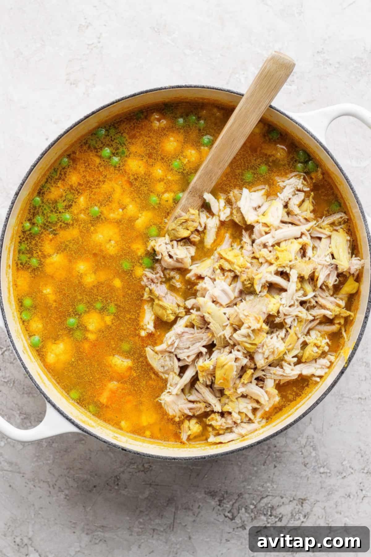 Chicken soup with shredded chicken and peas.