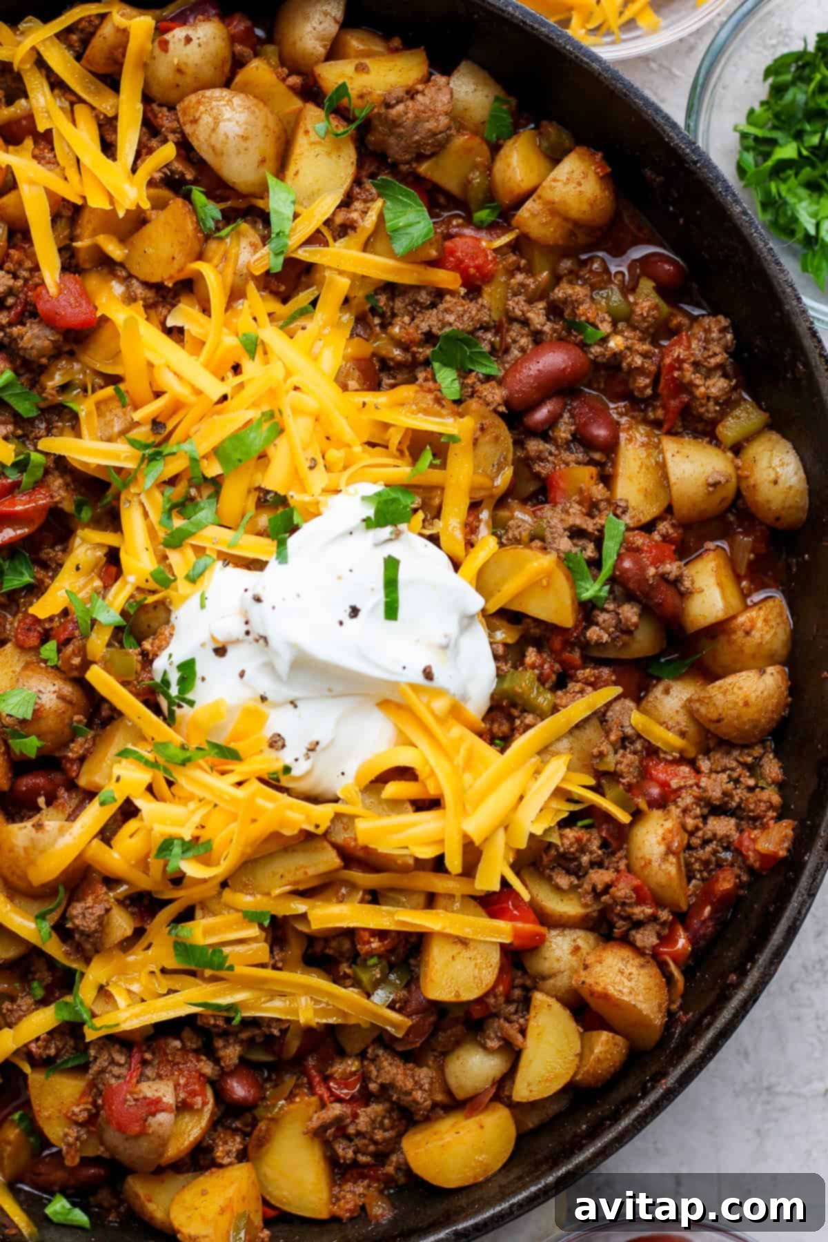 Finished potato chili skillet with toppings.