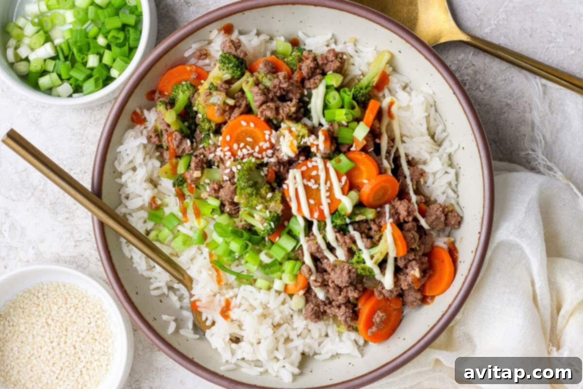 Ground Beef with Broccoli Florets 2 A delicious bowl of ground beef and broccoli served over white rice, garnished with green onions and sesame seeds.